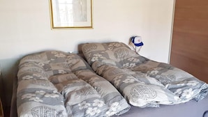 A bed with patterned bedding and a framed picture on the wall. - 6 Person Holiday Home in Taastrup (Taastrup)