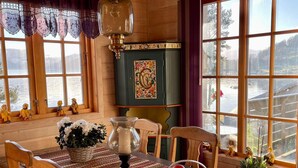A cozy dining area with wooden furniture, a table with a patterned tablecloth, a vase with flowers, and a fruit basket. - 6 Person Holiday Home in Hatlestrand-by Traum (Kvinnherad)