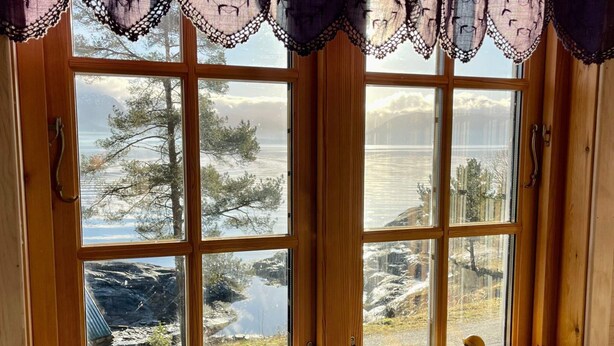 A room with large windows, wooden frames, and a view of a snowy landscape. - 6 Person Holiday Home in Hatlestrand-by Traum (Kvinnherad)