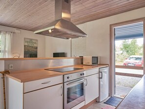 A modern kitchen with a stainless steel range hood, a microwave, and a built-in oven.