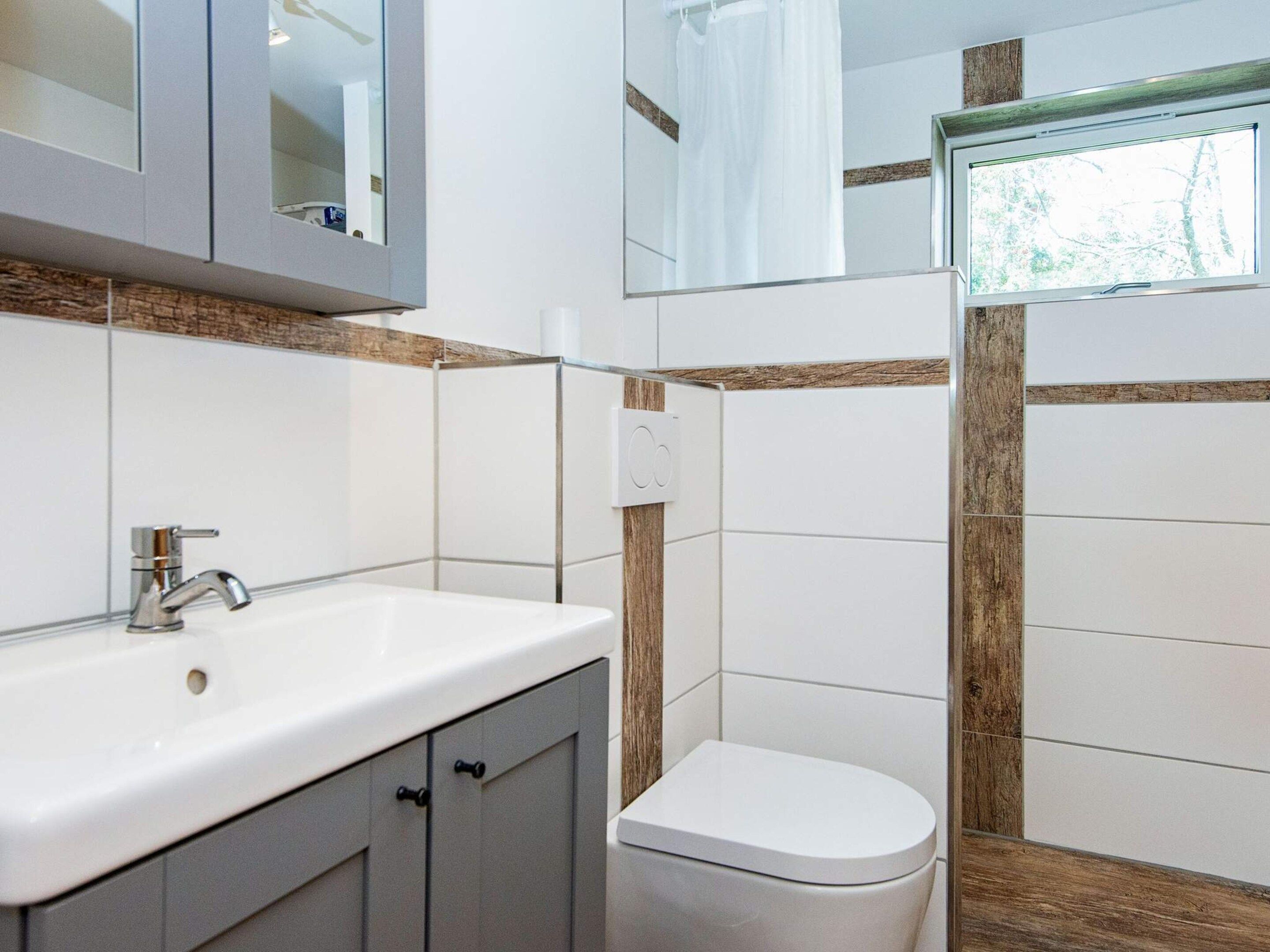 Une salle de bain avec un lavabo blanc, des toilettes et un espace douche.
