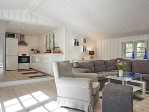 A modern kitchen with white cabinetry, a built-in oven, and a microwave.