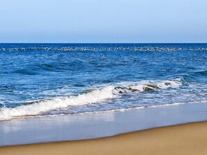 Uma praia com ondas e céu claro.
