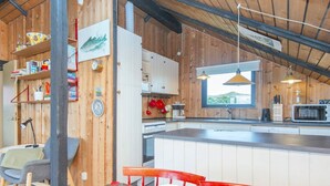 A kitchen with wooden walls, a window, a sink, and a microwave. - 6 Person Holiday Home in Harboore (Harboore)