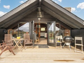 A wooden deck with outdoor seating, a grill, and a view of the surrounding landscape. - 6 Person Holiday Home in Harboore (Harboore)