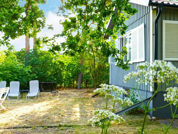 Una propiedad residencial con un patio, mobiliario exterior y un jardín.