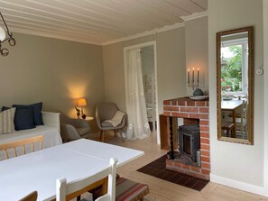 Un salon chaleureux avec une cheminée, une table à manger et un coin salon confortable.