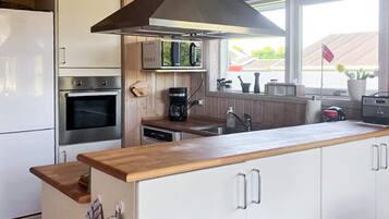 Eine moderne Küche mit Backofen, einer Kaffeemaschine und einem Fenster mit Blick nach draußen.