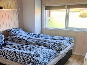 A room with a bed, a window, and a wooden wall. - 6 Person Holiday Home in Tranekaer (Tranekaer)