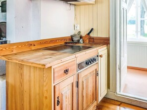 A wooden kitchen island with a sink, cabinets, and a window. - 3 Person Holiday Home in Flen (Flen)