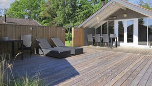 A wooden deck with outdoor furniture, a covered patio, and a view of the surrounding greenery. - 6 Person Holiday Home in Vaeggerlose (Vaeggerlose)