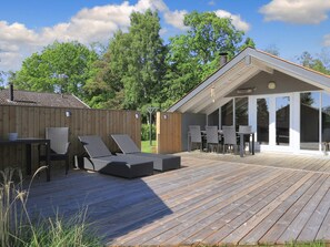 A wooden deck with outdoor furniture, a covered patio, and a view of the surrounding greenery. - 6 Person Holiday Home in Vaeggerlose (Vaeggerlose)