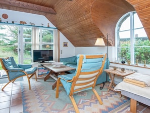 A cozy living room with a television, seating, and a large window. - 3 Person Holiday Home in Ringkobing (Ringkobing)