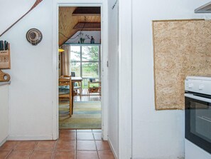 A kitchen with a wooden ceiling, a window, and a view of the outdoors.