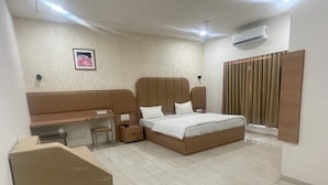 Ein Schlafzimmer mit einem Bett, einem Schreibtisch, einem Stuhl und einem Kleiderschrank.
