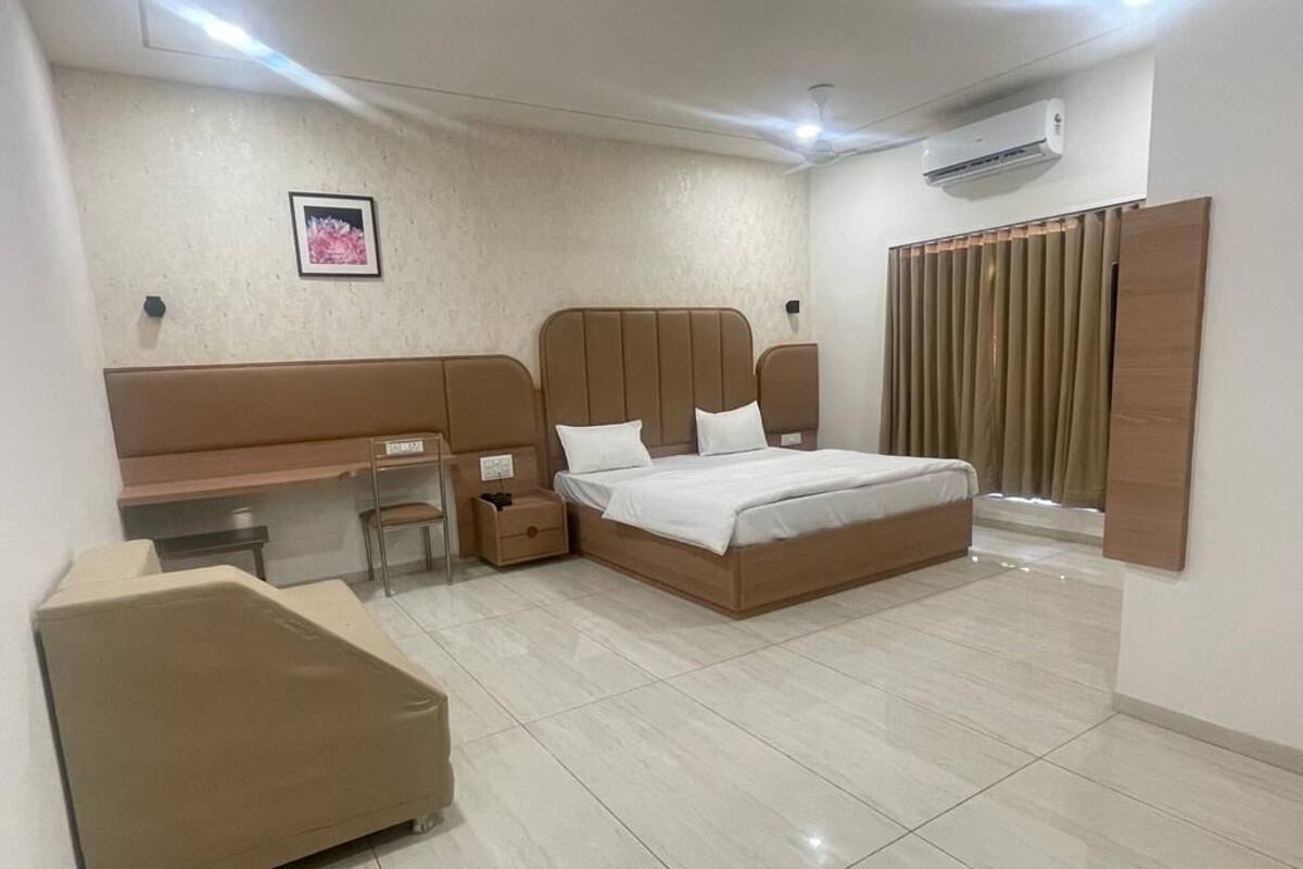 A bedroom with a bed, a desk, a chair, and a wardrobe.