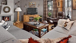 A cozy living room with a fireplace, a television, and comfortable seating. - 4 Star Holiday Home in Noresund (Krodsherad)