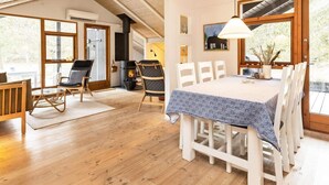 A cozy interior with a wooden dining table, chairs, and a fireplace. - 6 Person Holiday Home in Albaek (Aalbaek)