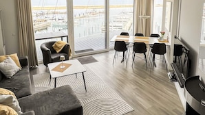 Un salon moderne comprenant un canapé, une table basse et un coin repas avec des chaises et une table.