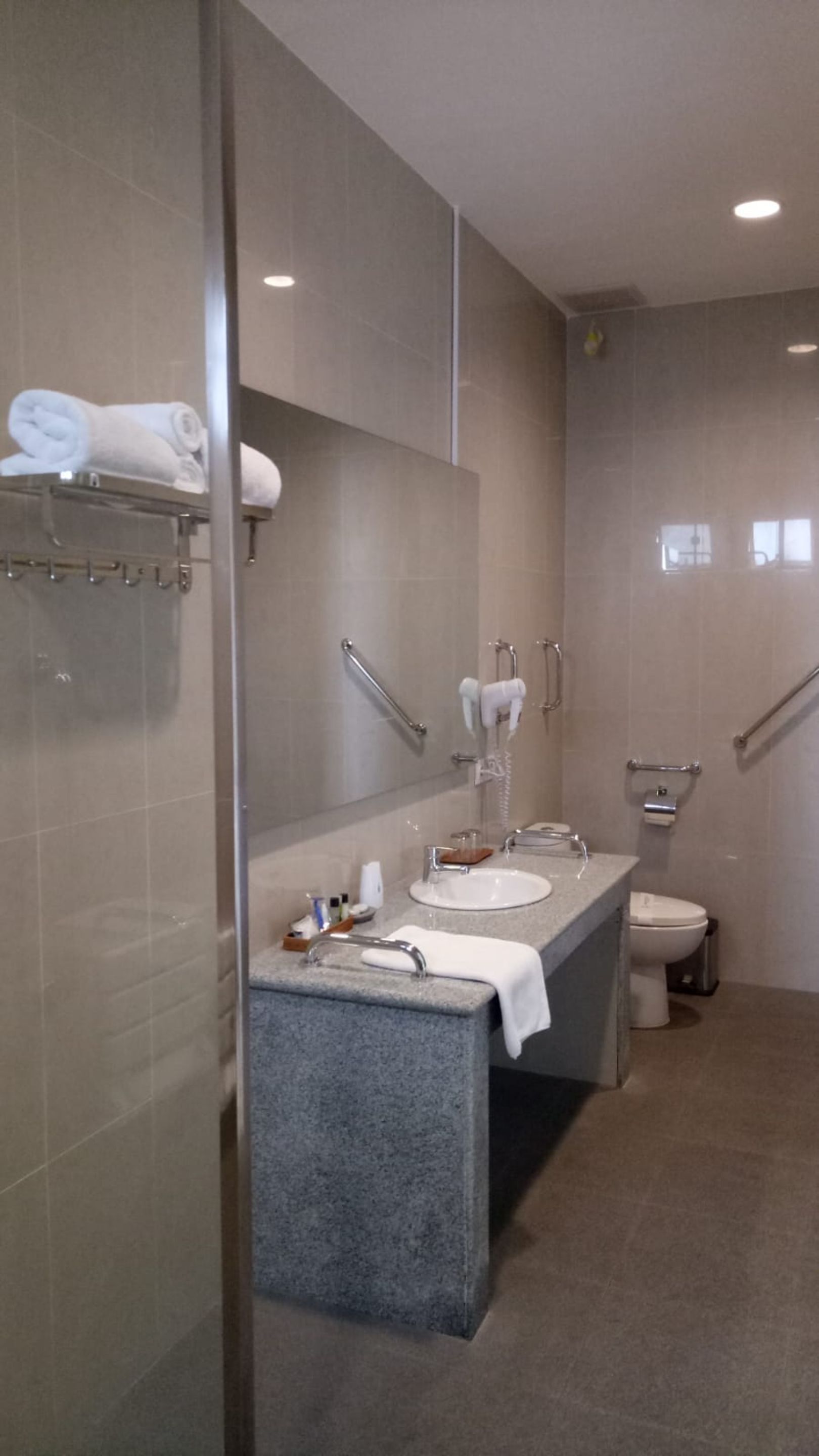 Een moderne badkamer met een douchecabine van glas, een wastafel met twee kommen en een toilet.