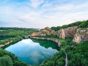 A natural landscape with a lake surrounded by cliffs and dense greenery. - 6 Person Holiday Home in Allinge (Allinge)