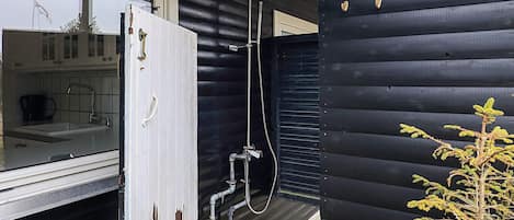 A wooden exterior with a sliding door leading to a bathroom.