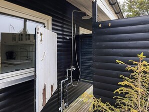 Fachada de madera con un acceso corredizo a un baño.