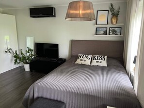 A bedroom with a bed, a television, a potted plant, and a wall-mounted air conditioner. - 4 Person Holiday Home in Varmdo (Värmdö)