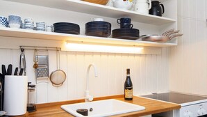 A modern kitchen with a wooden countertop, white sink, and a Bosch oven. - 4 Person Holiday Home in Hejls (Hejls)