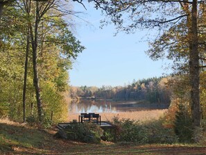 A lakeside setting with a table and chairs overlooking the water, surrounded by trees. - 4 Person Holiday Home in Skanes-fagerhult (Skånes Fagerhult)