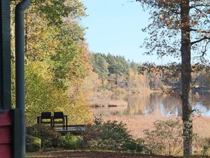 A lakeside view with a bench and a wooden deck. - 4 Person Holiday Home in Skanes-fagerhult (Skånes Fagerhult)