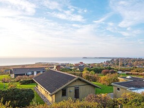A coastal residential area with houses, a clear sky, and a view of the sea. - 6 Person Holiday Home in Knebel (Knebel)
