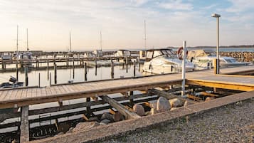 Un puerto deportivo con barcos amarrados, pasarelas de madera y un cielo despejado.