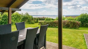 An outdoor patio with a view of the sea, featuring a table and chairs. - 6 Person Holiday Home in Knebel (Knebel)
