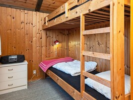 Habitación con literas, un escritorio, una lámpara y una radio.