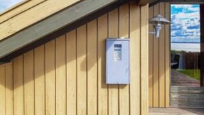 A wooden exterior wall with a utility box and a pathway leading to a door. - 6 Person Holiday Home in Knebel (Knebel)