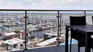 Un balcon donnant sur une marina où sont amarrés de nombreux bateaux.