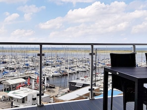 A balcony with a view of a marina filled with boats.