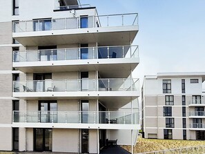 A multi-story residential building with balconies, a flat roof, and a simple facade. - 5 Star Holiday Home in Wendtorf (Wendtorf)