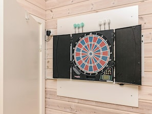 A dartboard mounted on a wall with a wooden panel background.
