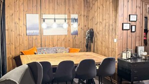 A modern dining area with a wooden table, black chairs, and a bench with orange cushions. - 8 Person Holiday Home in Loten-by Traum (Loten)