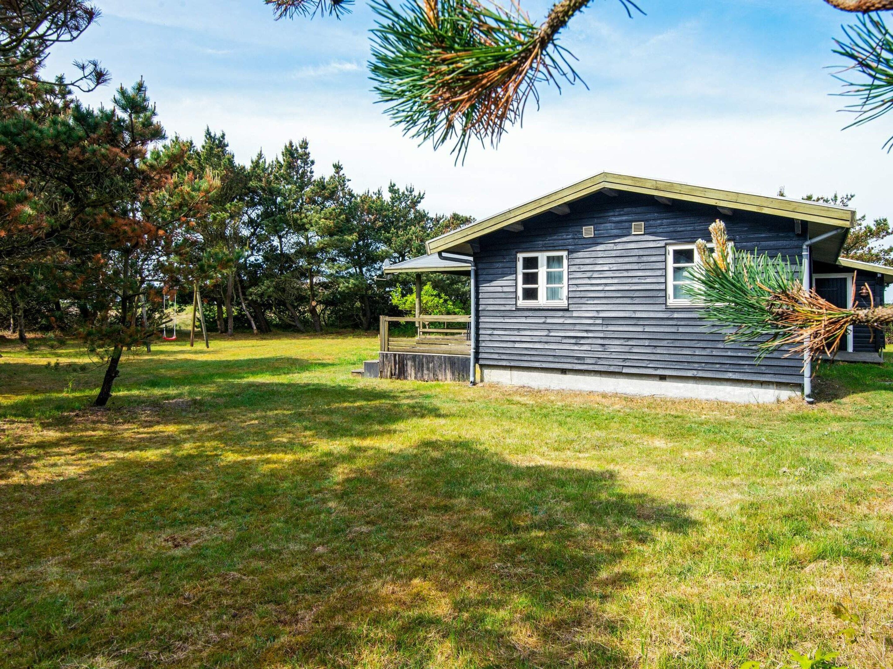 Een gelijkvloers huis met schuin dak, een veranda en een klein terras.