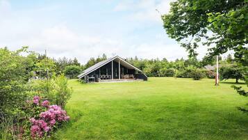 A modern barn with a flat roof and a covered patio area.
