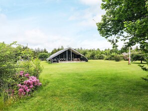 A modern barn with a flat roof and a covered patio area.