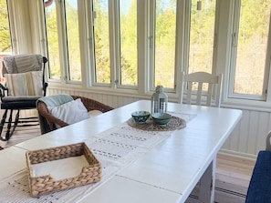 A dining area with a white table, woven basket, and two bowls on a placemat. - 5 Person Holiday Home in Haradsback (Ryd)