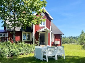 A red house with a white porch and a table with chairs. - 5 Person Holiday Home in Haradsback (Ryd)