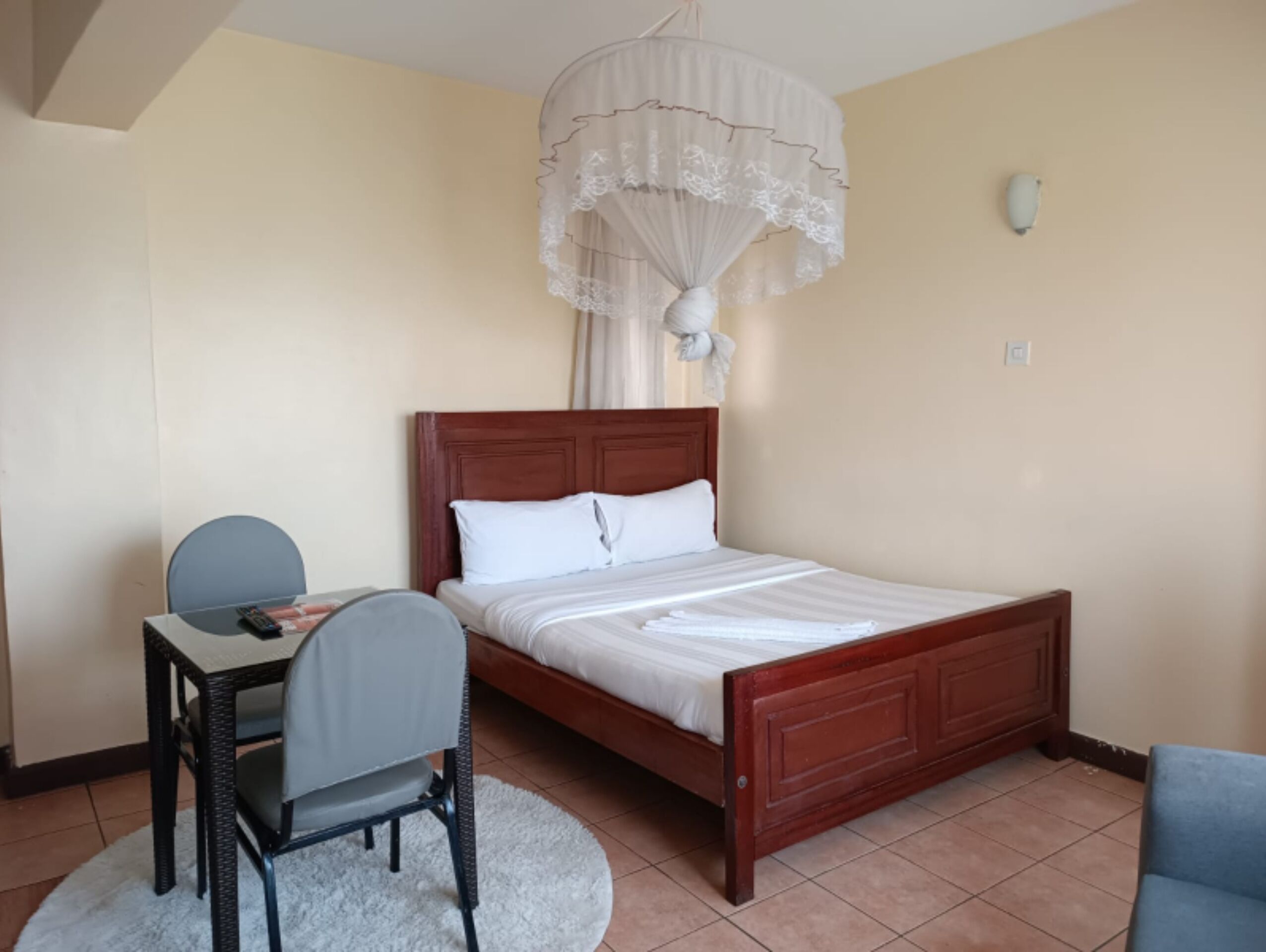 A bedroom with a wooden bed, a desk, and a chair.