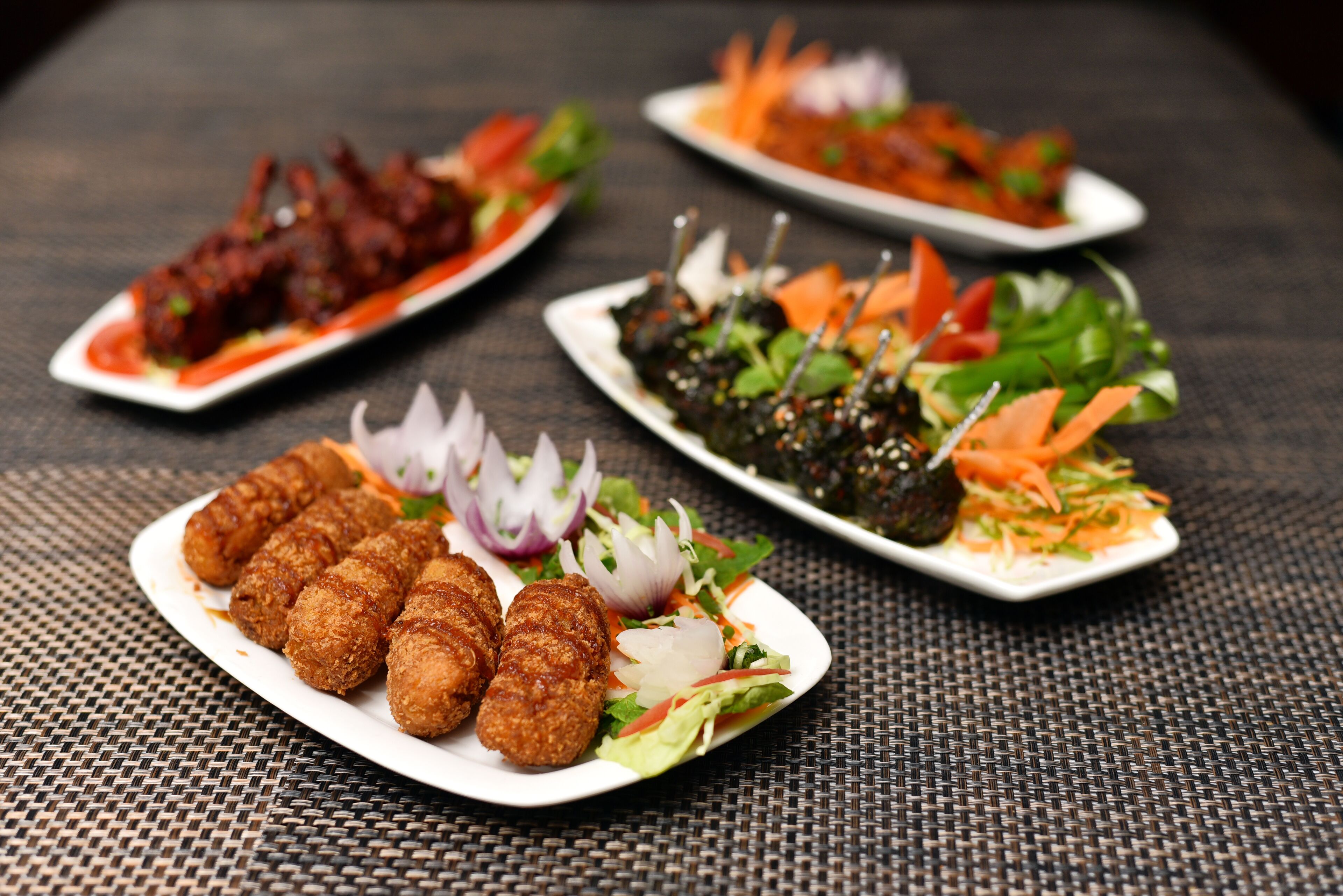 Une table avec trois assiettes de nourriture, chacune contenant des plats différents.