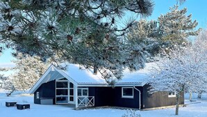 A cabin with a large window, a door, and a fenced yard. - 4 Star Holiday Home in Rodby (Rodby)