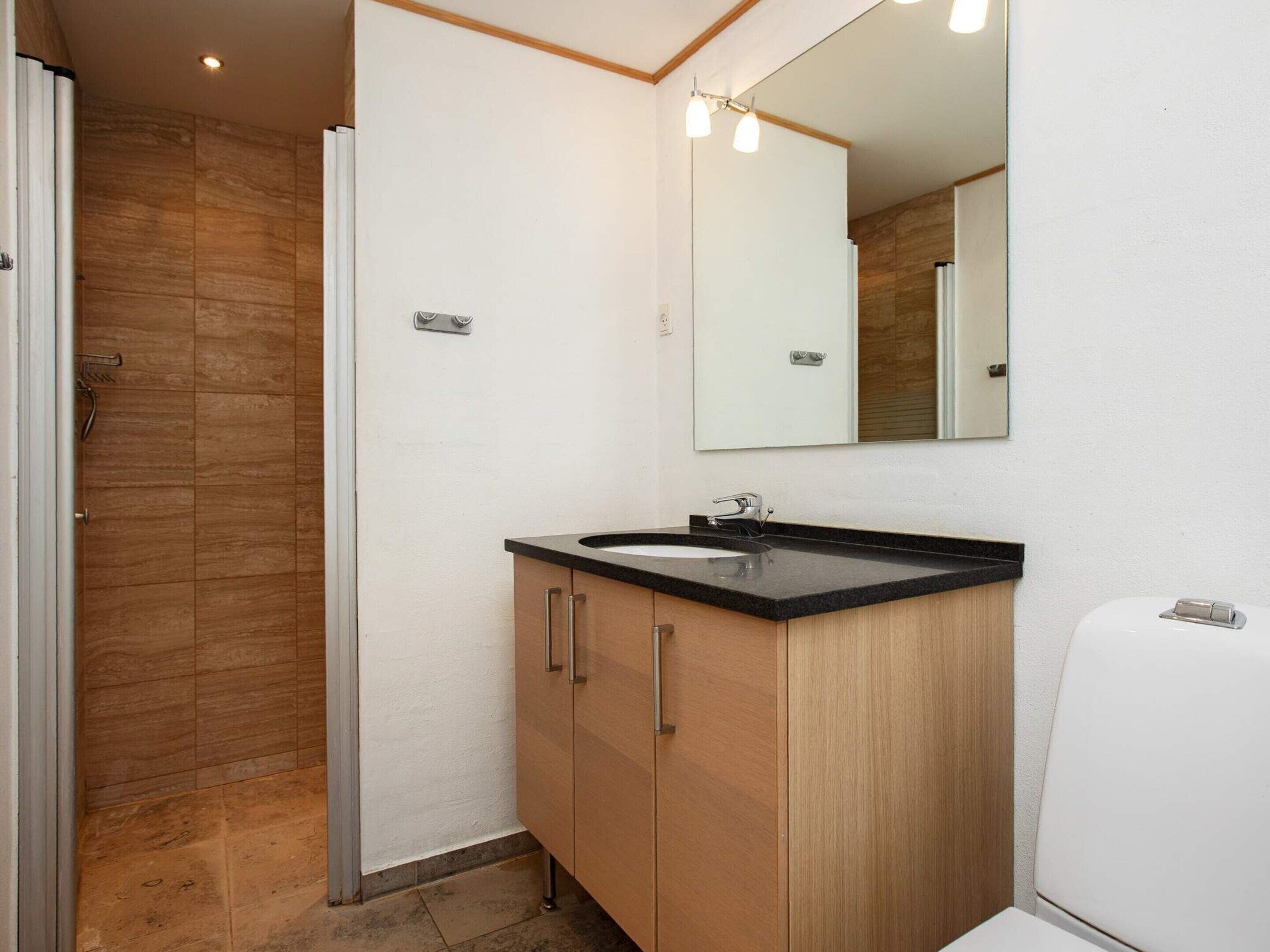 A bathroom with a shower, sink, and toilet.